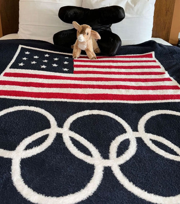 Olympic gymnast Simone Biles posted a photo on IG of her Olympic Village room in Paris with her Barefoot Dreams Team USA Flag Throw