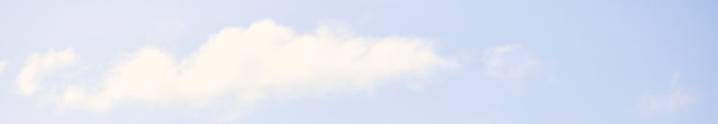 Two small white clouds against a light blue sky